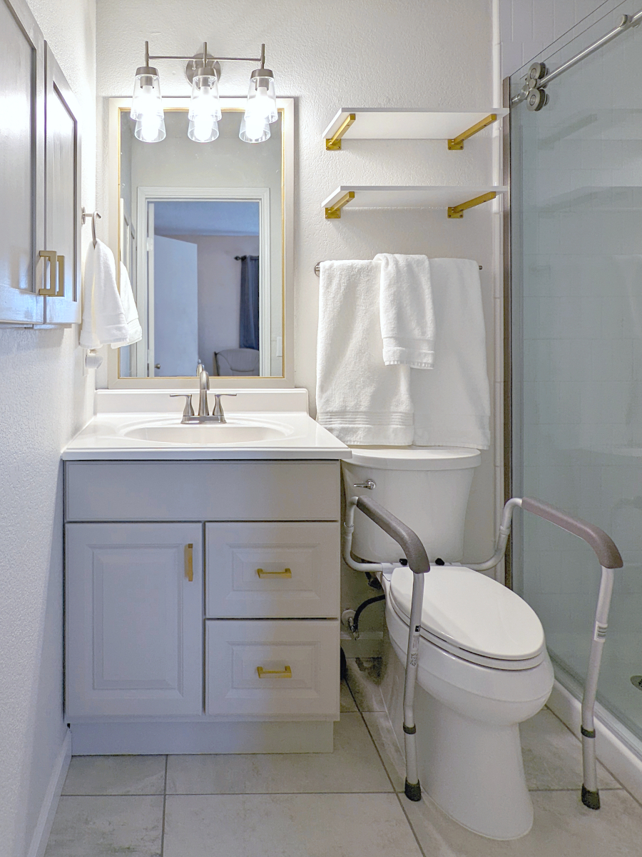 Image of small bathroom after remodel. Image shows off white bathroom with gold accents