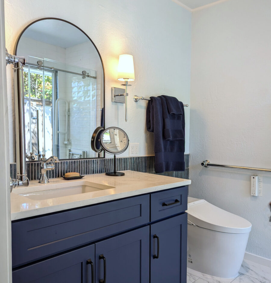 Blue_Bath_Remodel-Blue_Vanity_Contemporary_Elegant Small bathroom with blue vanity, chrome fixtures and black accent mirror and pulls. Elegant, transitional design. Marble look tile