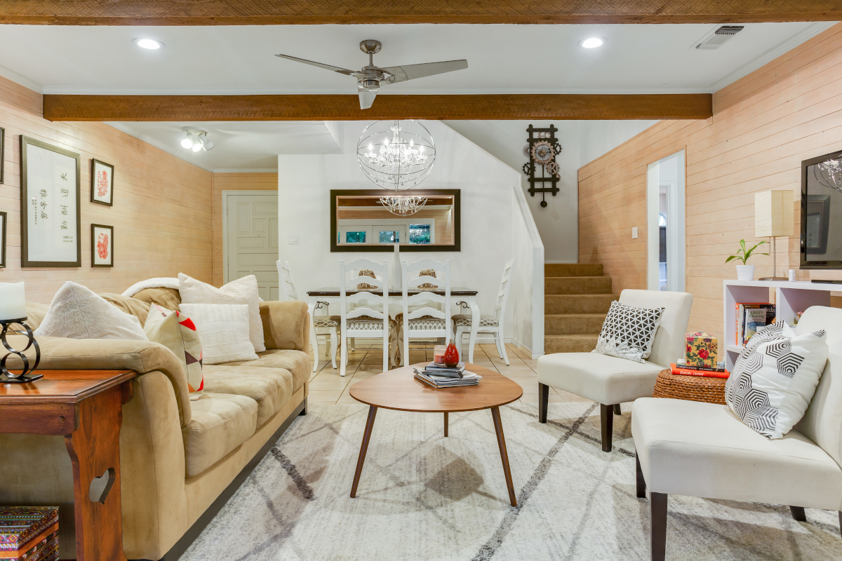 After image of living and dining area with white-washed walls, wood beams and contemporary furnishings